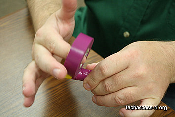 photo of person wrapping barrel and wire with purple electrical tape