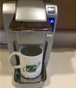 This is a picture of a Keurig single serve coffee pot with a TechACCESS mug 