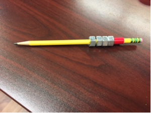 This is a picture of a pencil wrapped with tape with 4 hex nuts added under the tape