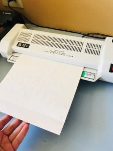 Photo of laminator with laminator pouch being fed in