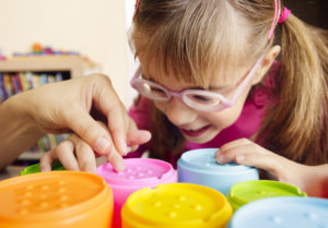 visually impaired girl touching 3d printed blocks with braille