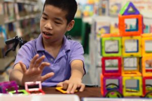 Young boy building with colored blocks